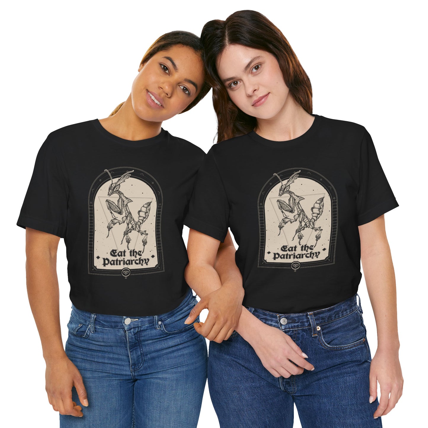 a young lesbian couple wearing matching blue jeans and goth black tees with a witchy feminist praying mantis illustration that says "eat the patriarchy"