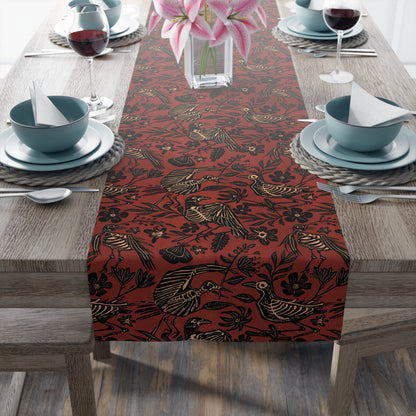 macabre autumn folk art floral bird skeleton table runner in rust red orange on an elegant table with ceramic dishes and a vase of lillies