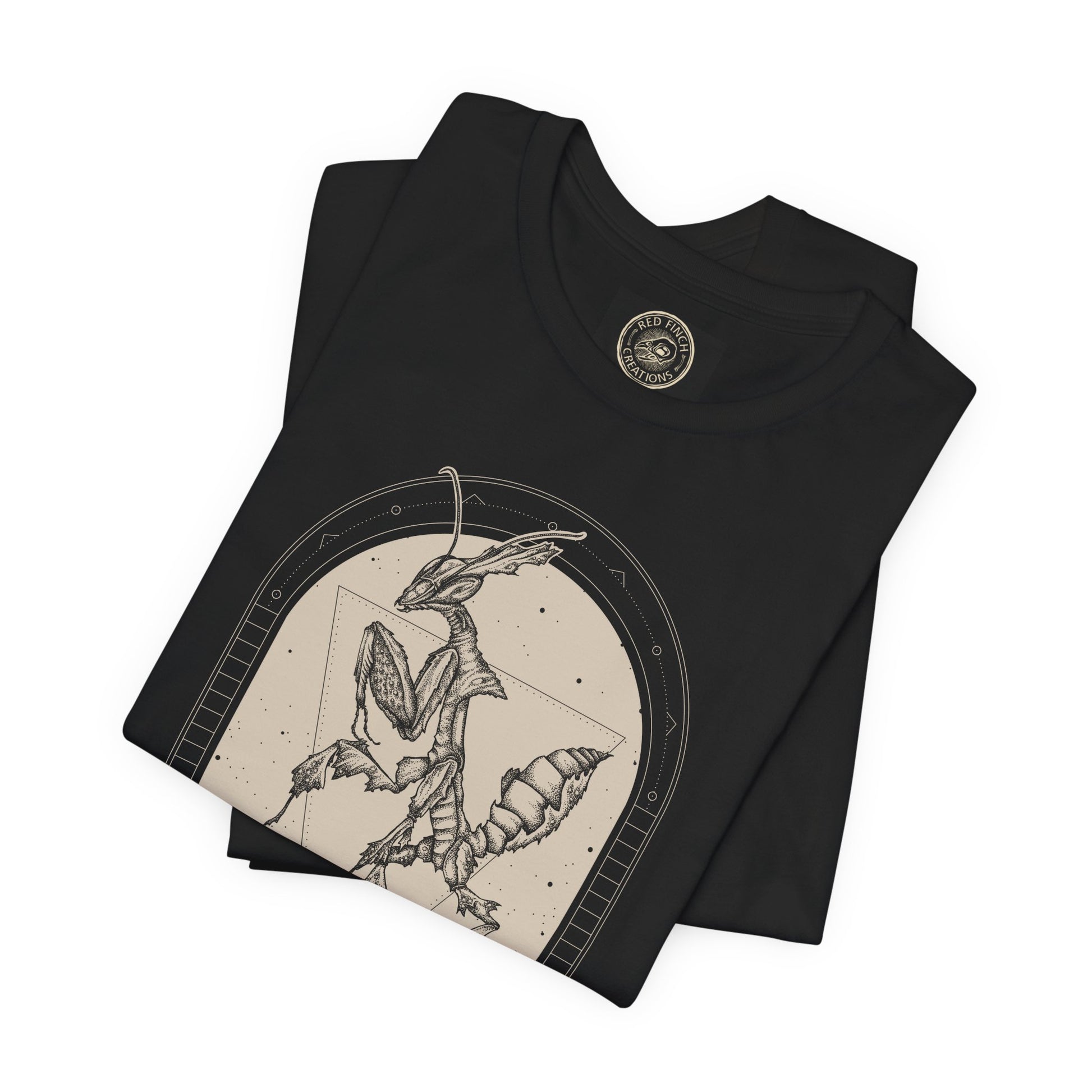 a witchy occult ghost mantis illustration on a folded black tee by cred finch creations