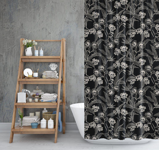 a spooky gothic floral skull flower shower curtain with dark cottagecore vibes in black and cream in a rustic bathroom with wooden shelves and vintage distressed walls.