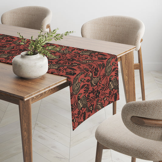 spooky autumn floral bird skeleton table runner in black and rust red on a simple wooden table with cottagecore vibes