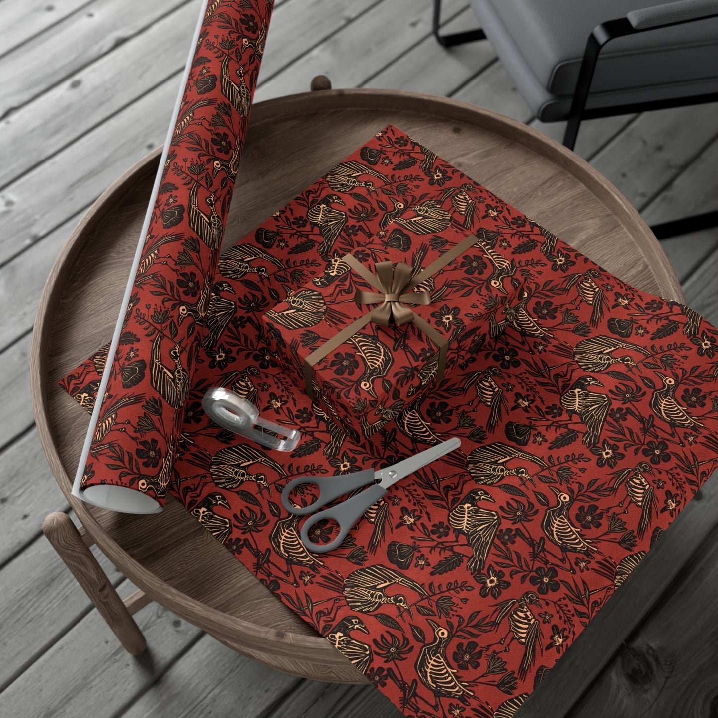 Red and black spooky fall floral patterned gift wrap with scissors on a wooden surface
