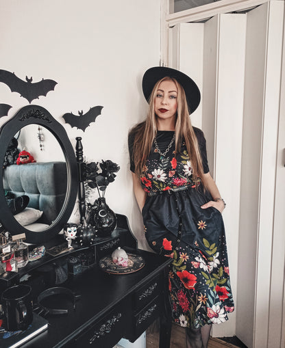 moody floral watercolor blouson dress on a gothic woman in a black hat and fishnet stockings