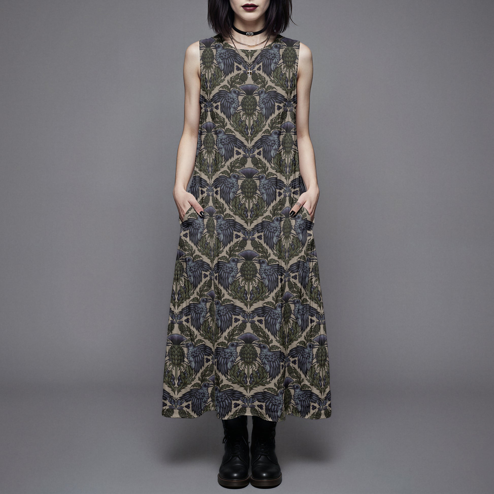 goth woman wearing a witchy raven thistle cotton dress with pockets against a gray background
