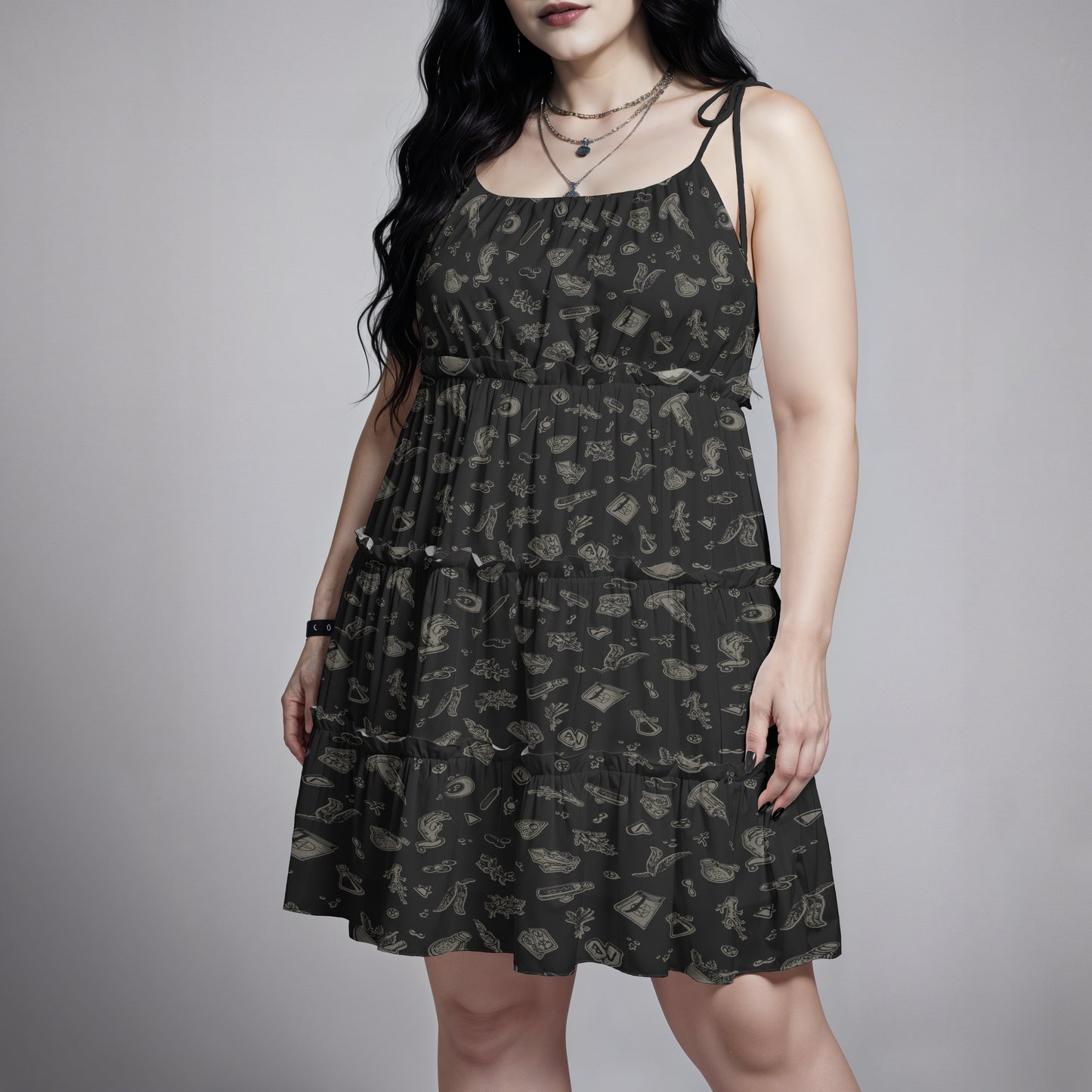 Gothic woman wearing a black patterned witchy spells and potions dress against a gray background