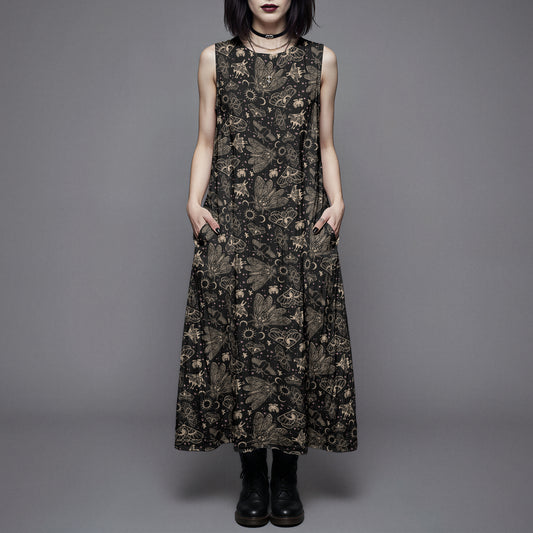 Woman wearing a long black dress with a witchy moth and cicada print against a gray background