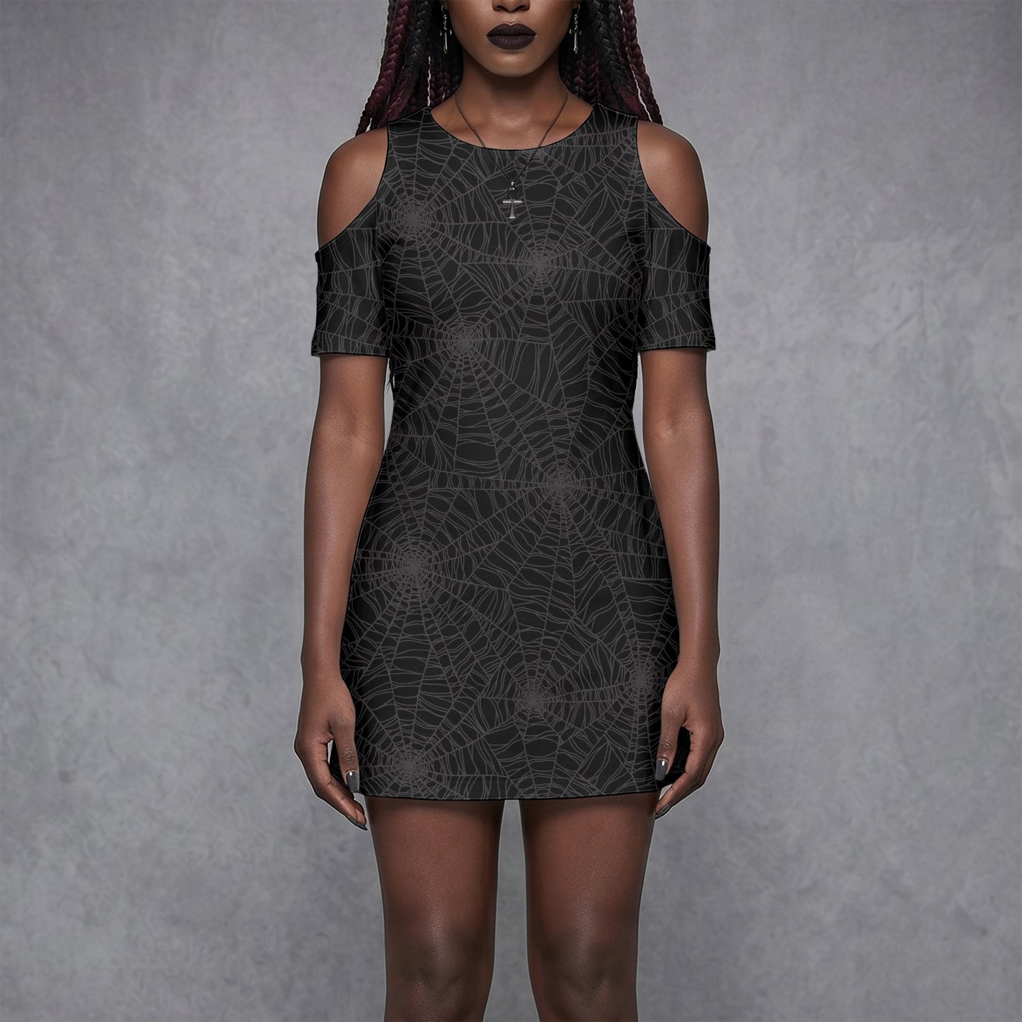 Goth Woman wearing a black spider web cold shoulder dress with spooky vibes against a gray background