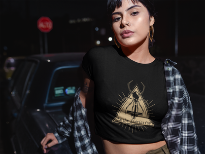 Woman wearing a black eat the patriarchy t-shirt with a spider design, standing outdoors at night.