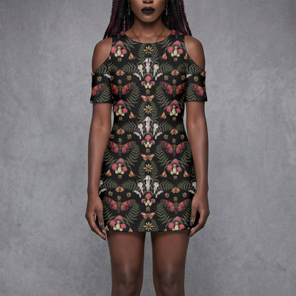 goth woman wearing a witchy floral skull mushroom moth patterned dress against a gray background