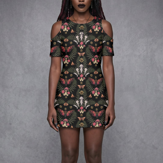 goth woman wearing a witchy floral skull mushroom moth patterned dress against a gray background