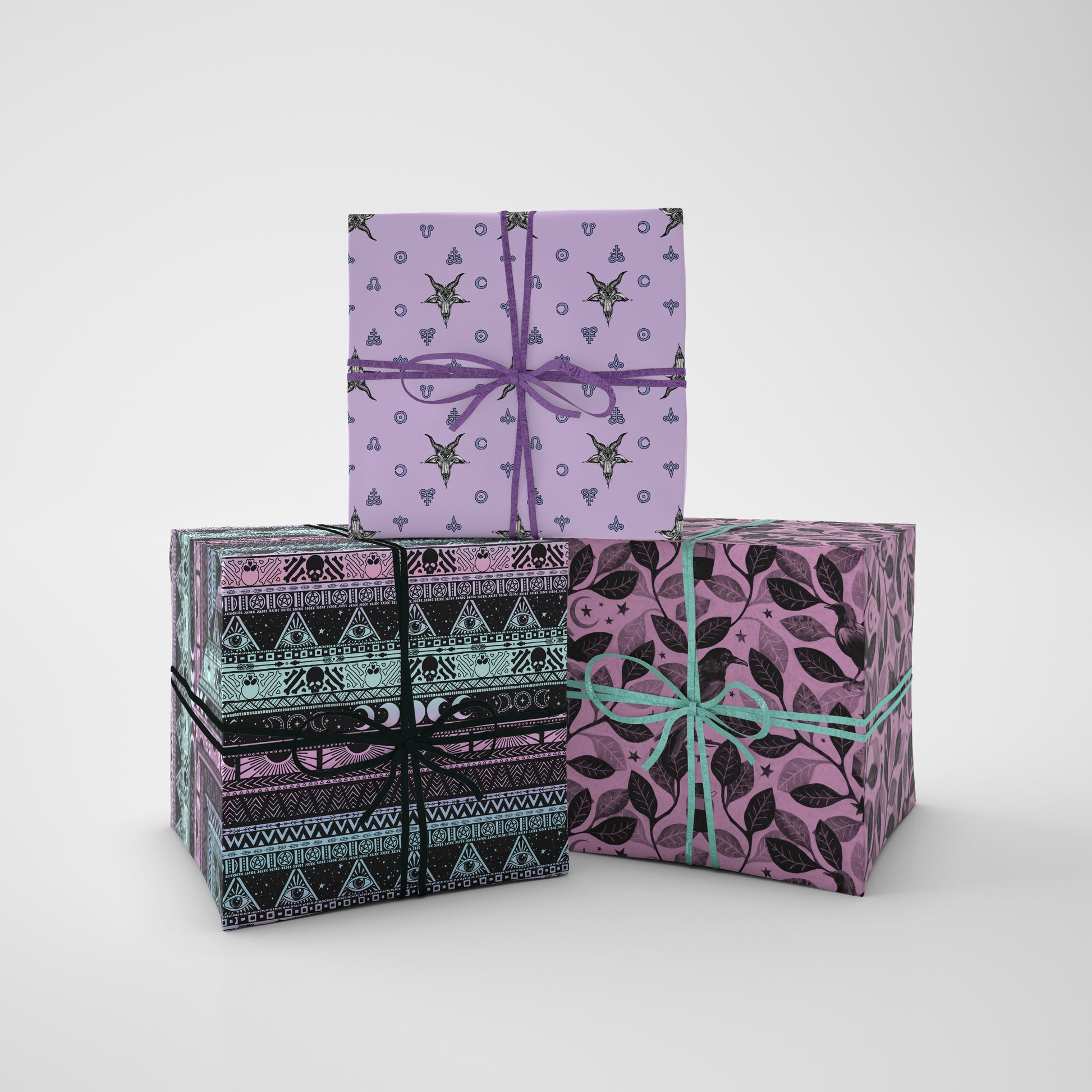 Four gift boxes with pastel goth patterned wrapping paper and ribbons on a white background