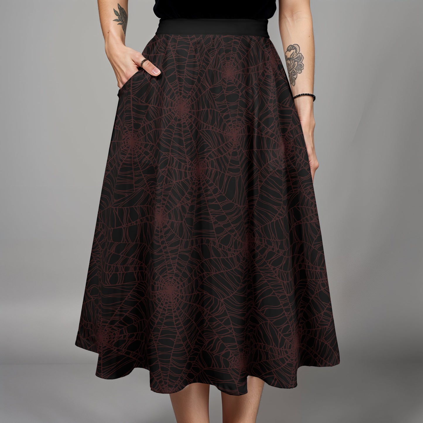 Dark burgundy and black spider web midi skirt skirt worn by a goth woman with tattoos on a gray background