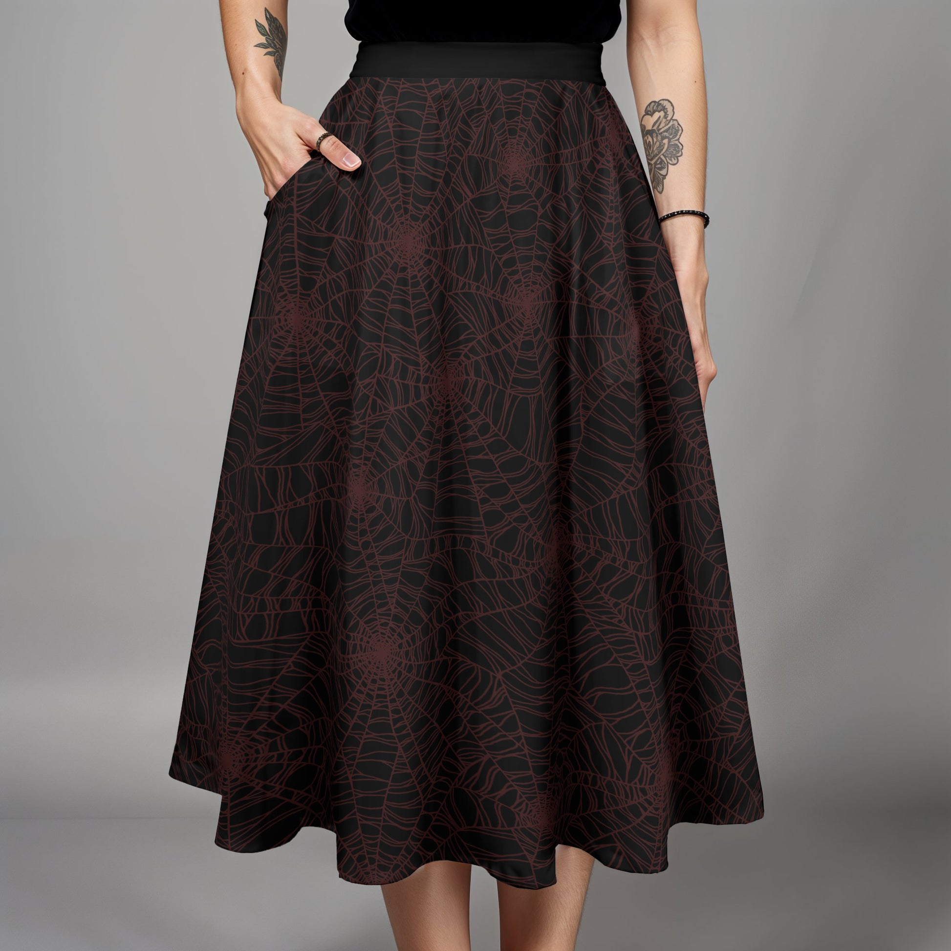 Dark burgundy and black spider web midi skirt skirt worn by a goth woman with tattoos on a gray background