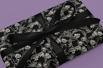Gift wrap with black gothic floral pattern and black ribbon on a purple background