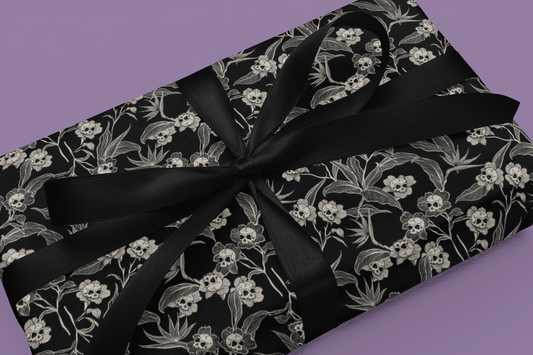 Gift wrap with black gothic floral pattern and black ribbon on a purple background