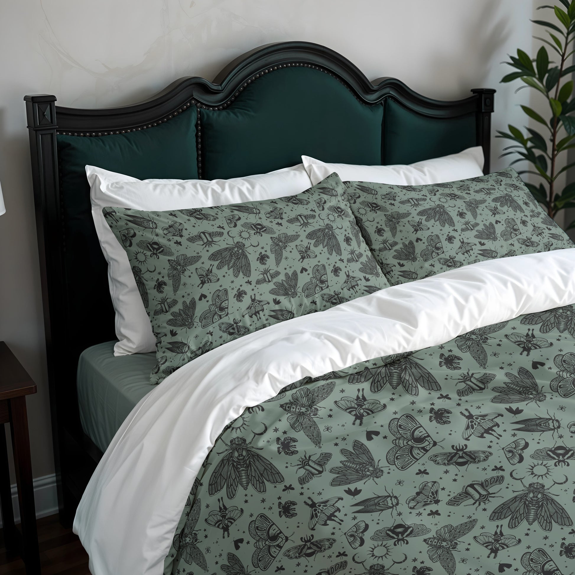 Bed with green and white bedding featuring moth patterns, dark wood headboard, and plant in corner.