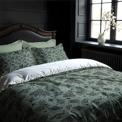 gothic Bed with witchy green and black patterned bedding in a room with dark walls and a window.