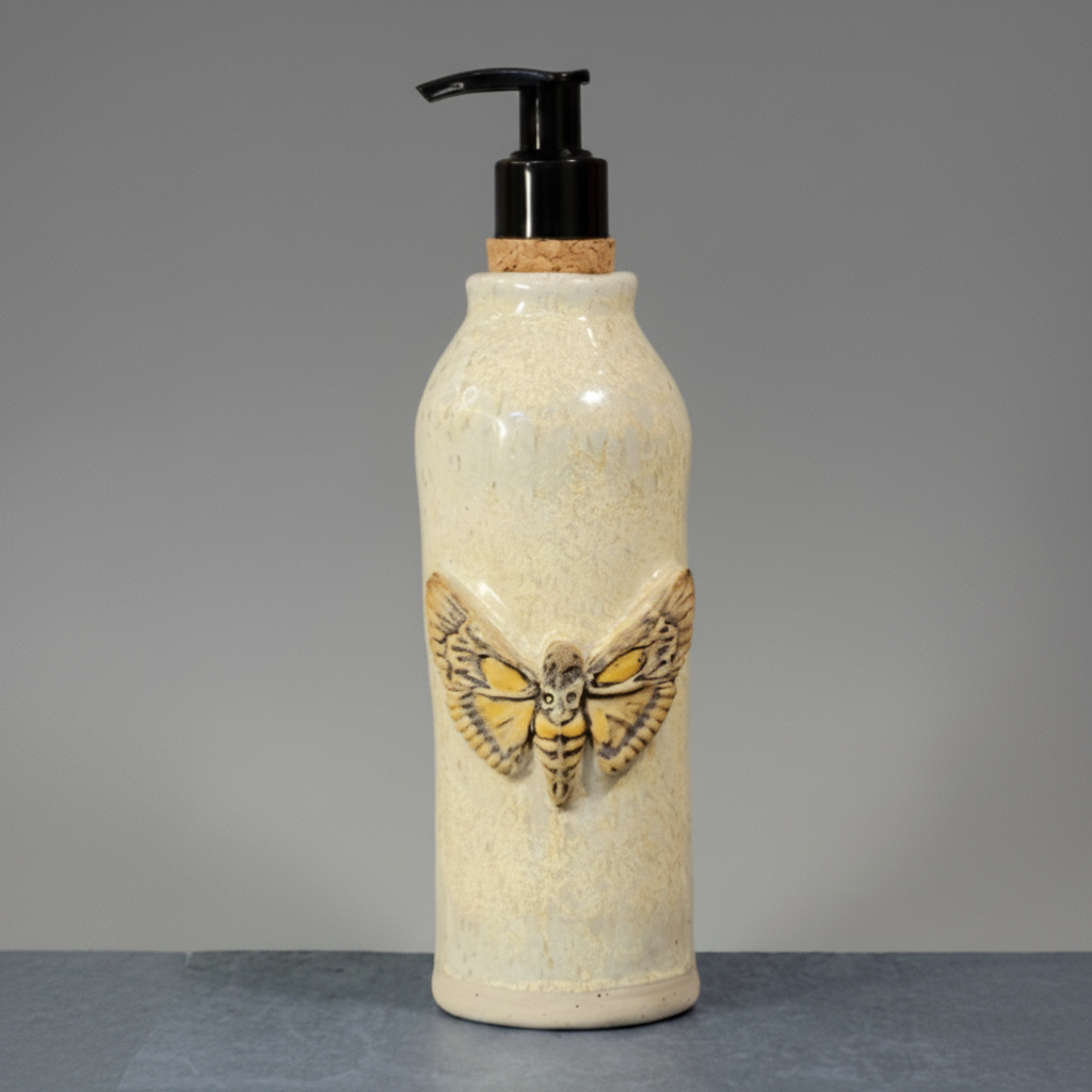 Ceramic bottle with moth design and pump on a gray background