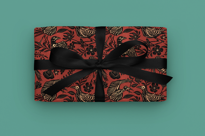 Gift with gothic red floral skeleton pattern and black ribbon on a teal background