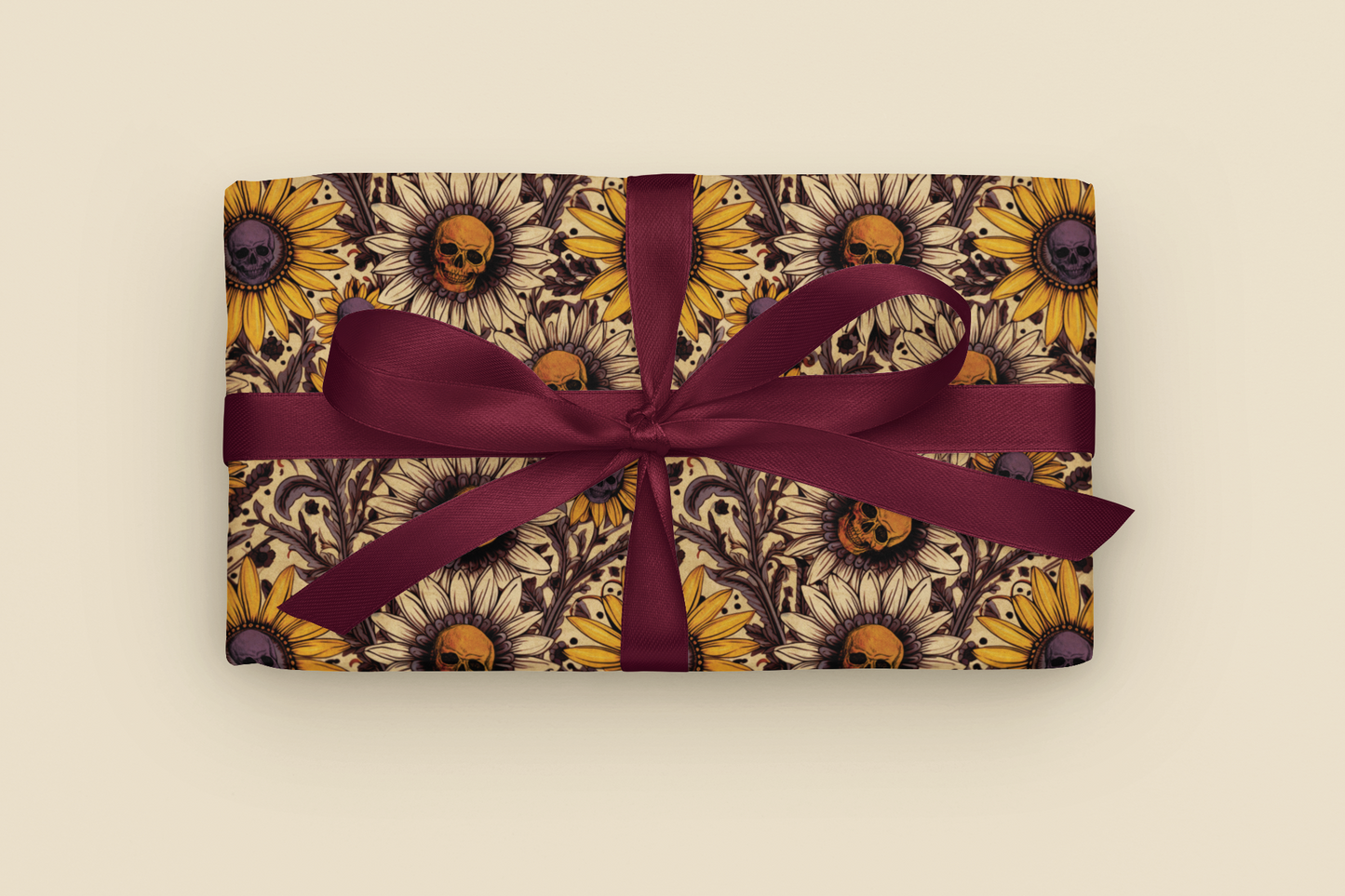 Gift with gothic sunflower and skull pattern wrapping paper with a purple ribbon on a beige background