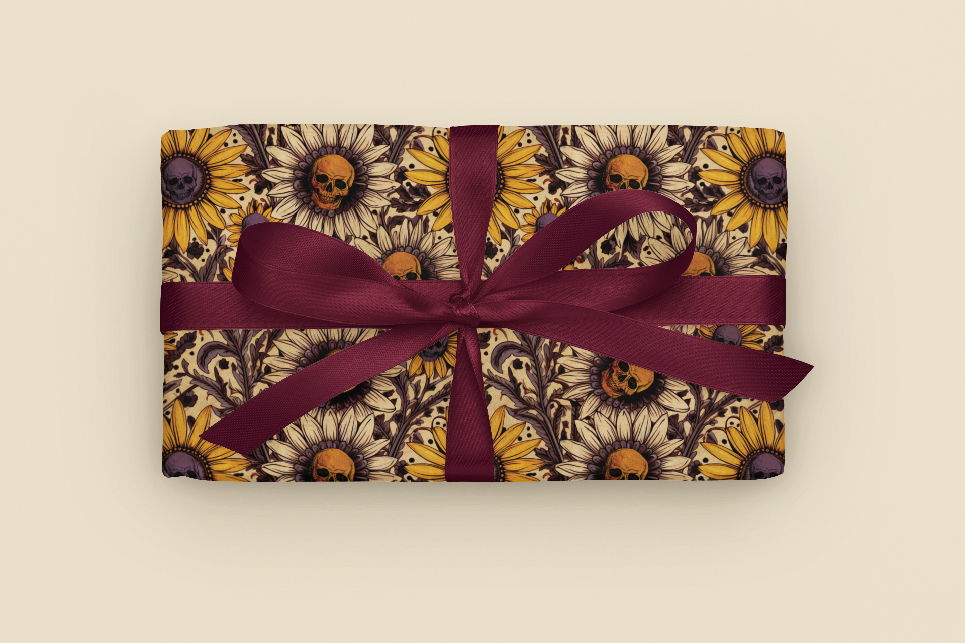 Gift with gothic sunflower and skull pattern wrapping paper with a purple ribbon on a beige background