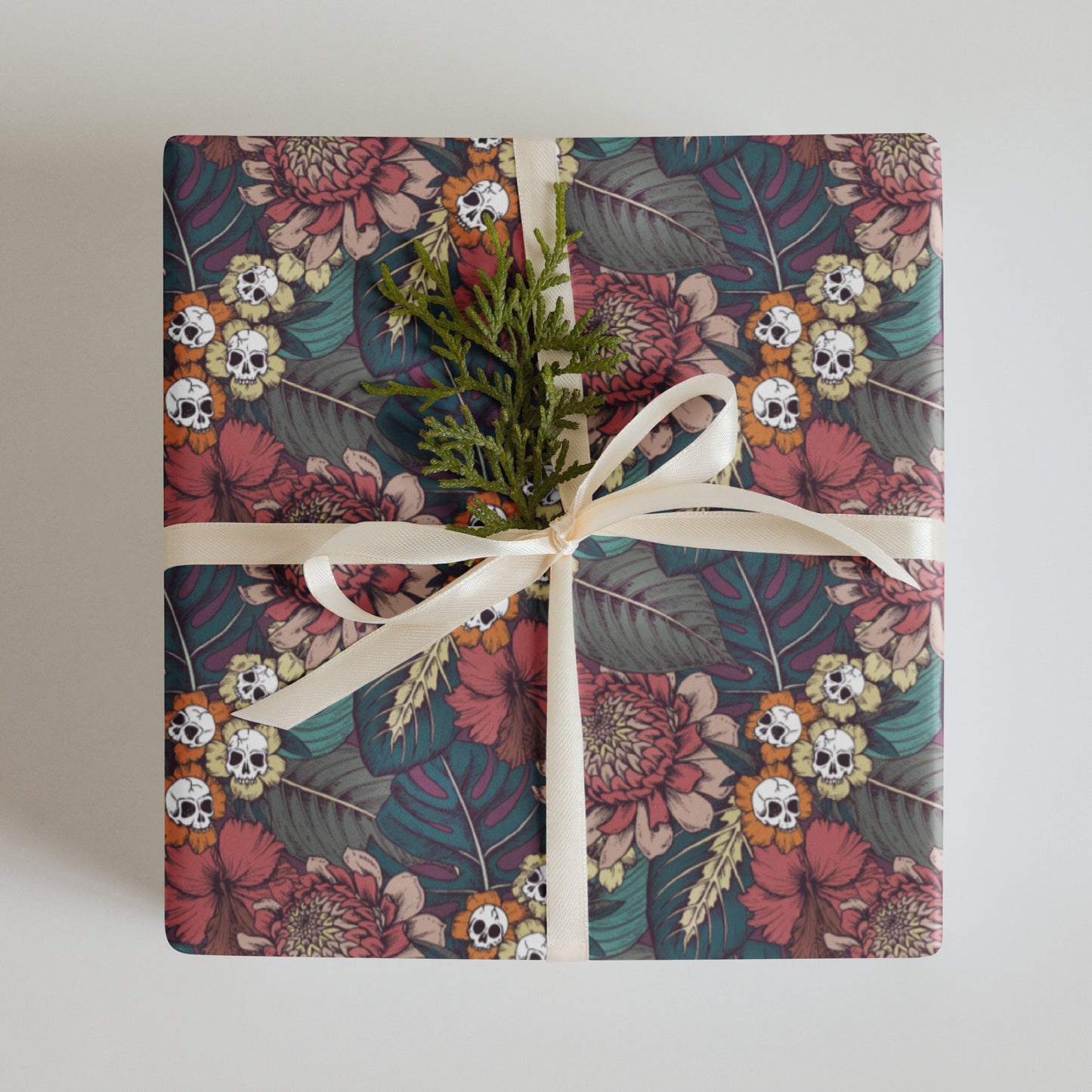 Gift wrapped in floral skull paper with a white ribbon on a light background