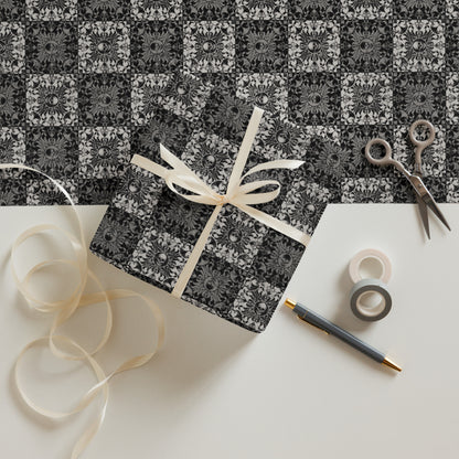 Gift box with decorative ribbon on a patterned surface with scissors and tape.