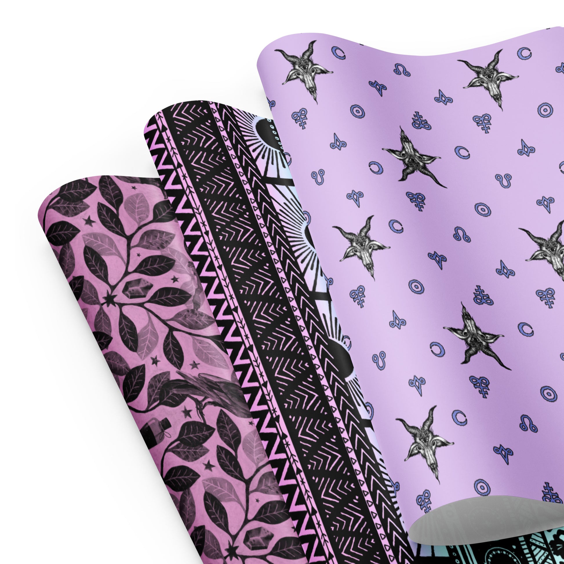 Three sheets of pastel goth gift wrap on a white background