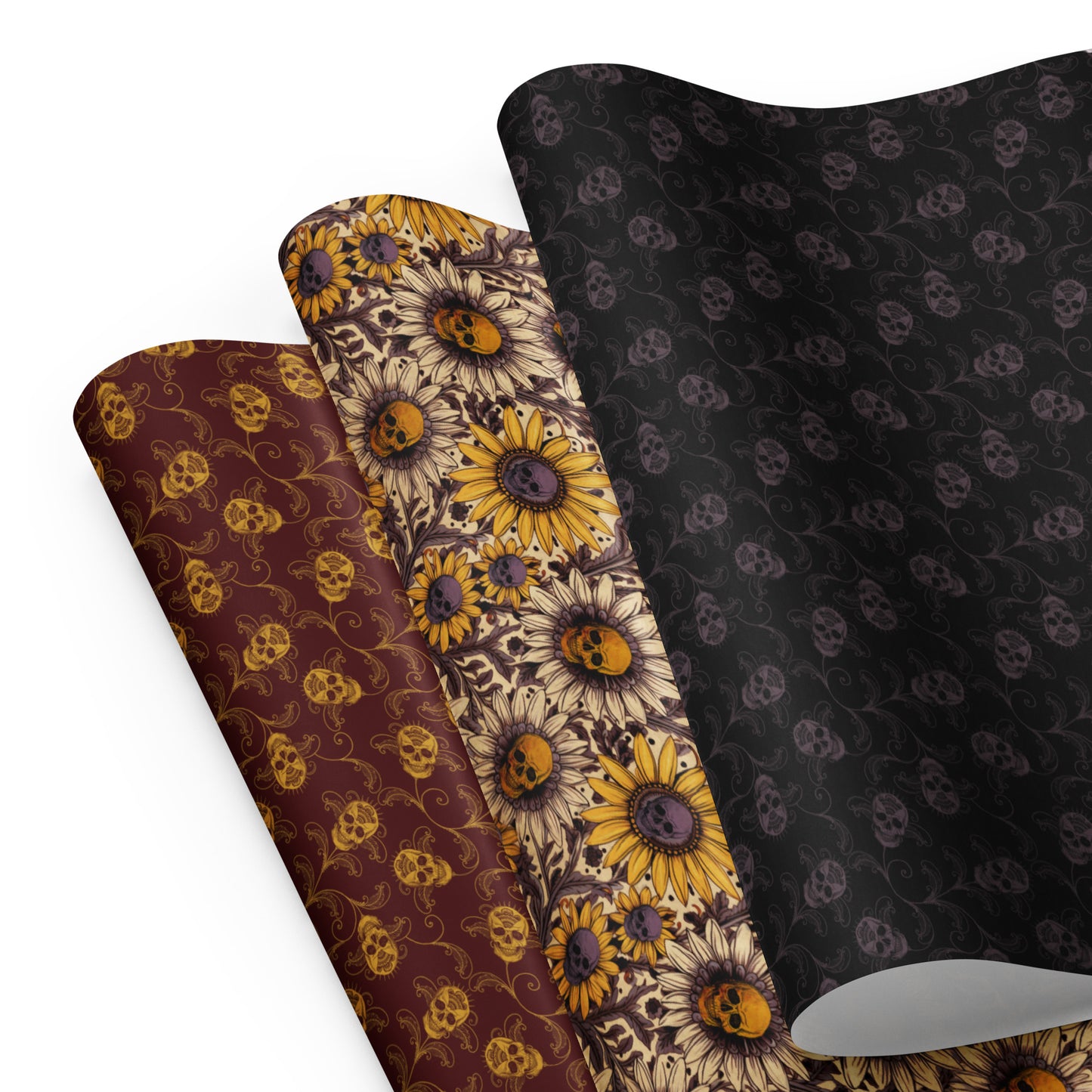 Three gothic wrapping paper sheets with floral and skull patterns on a white background